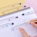 stage for kids A person using creative stationery draws a simple astronaut ruler on a piece of paper.
